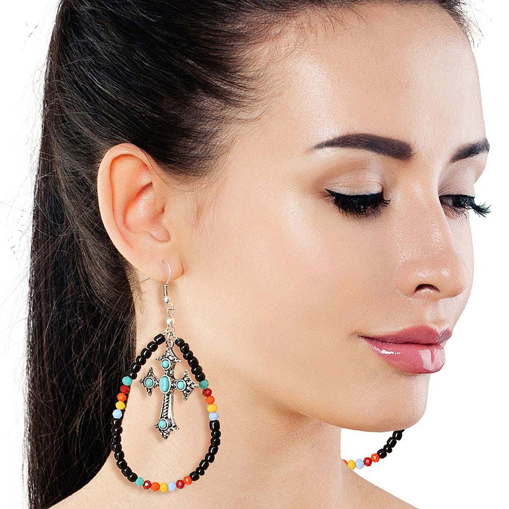 Handcrafted black bead cross earrings worn on ear boho side view