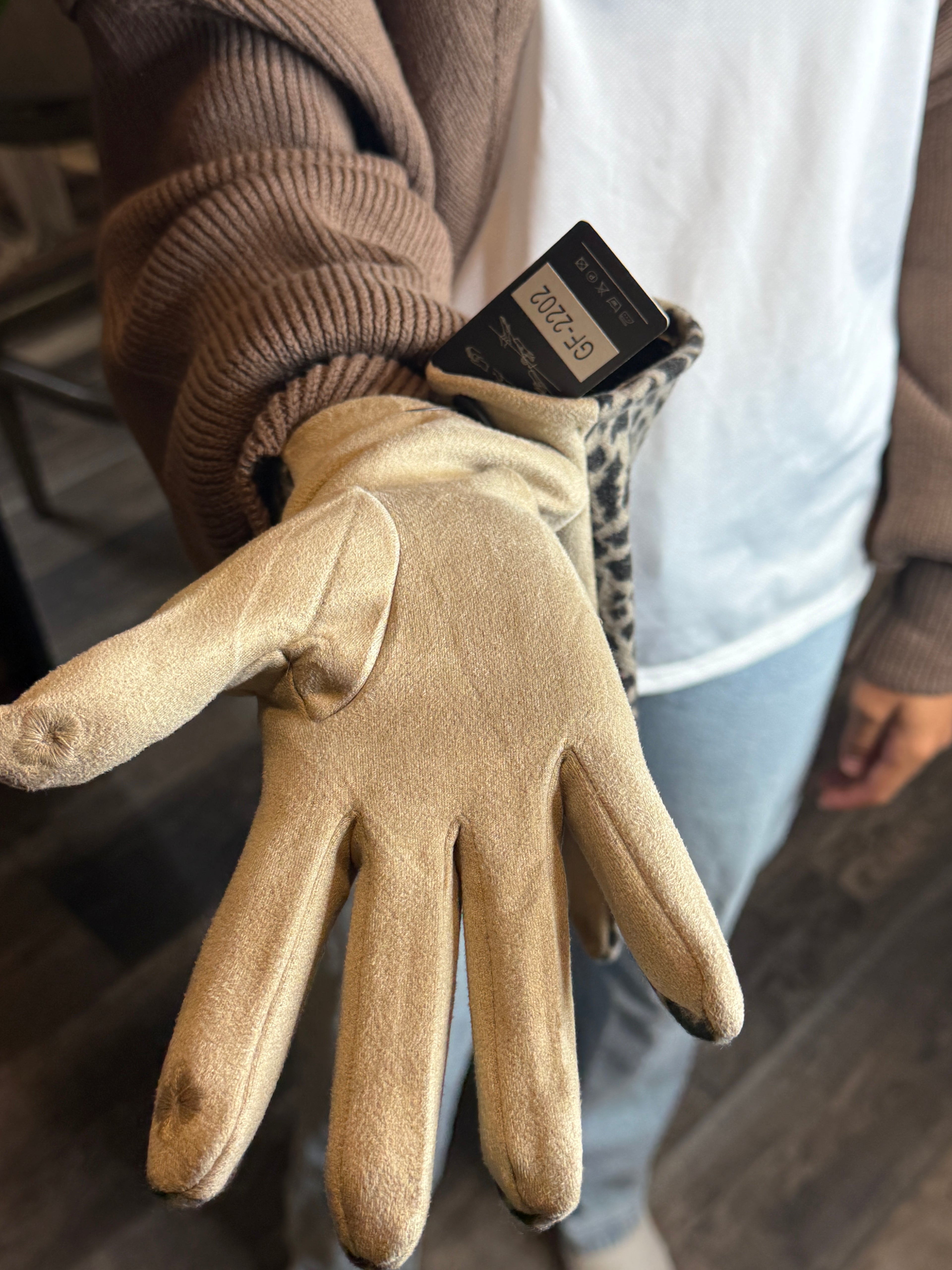 Beige work glove with a brand tag on a blurred background