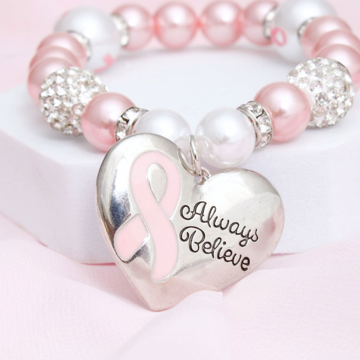 Light pink pearl breast cancer heart charm bracelet on wrist