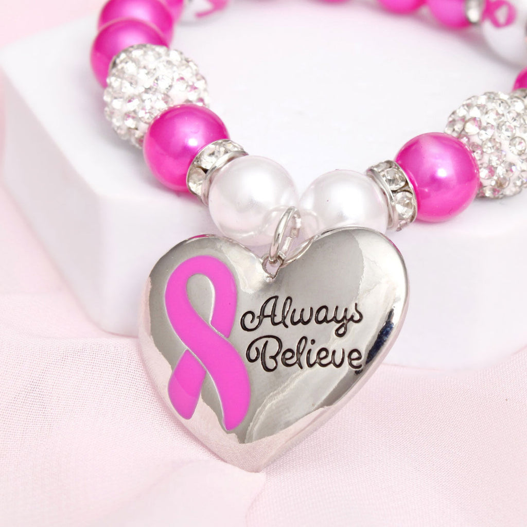 Fuchsia pink pearl breast cancer heart charm bracelet on wrist