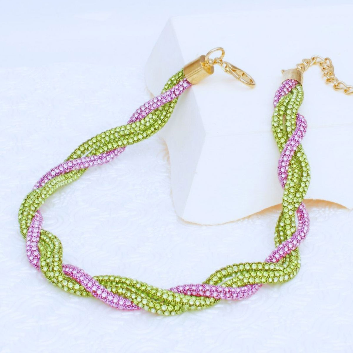 Pink green vibrant twisted tube necklace worn on neck front view bold
