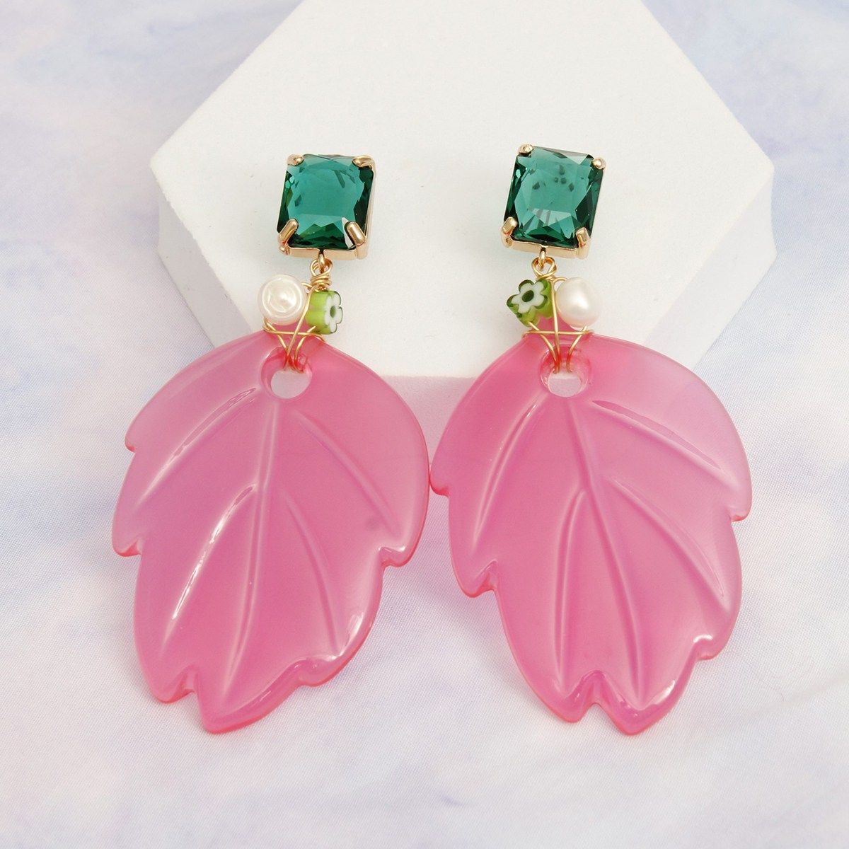 Pink green tropical leaf drop earrings worn on ear front view bold
